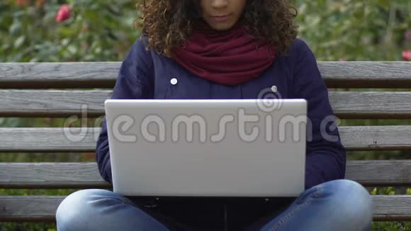 双种族女性自由职业者在公园的笔记本电脑工作自由职业电子商务视频的预览图