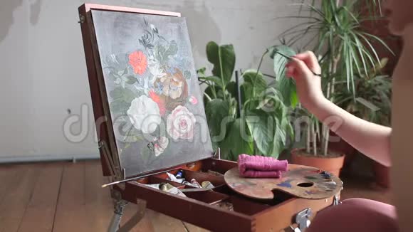 年轻的女画家在画室画架上画着油画画的还是一幅艺术创意爱好概念视频的预览图