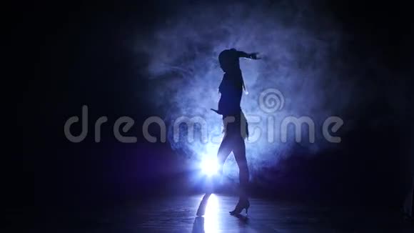 女人在工作室跳舞剪影深色背景蓝色背光视频的预览图
