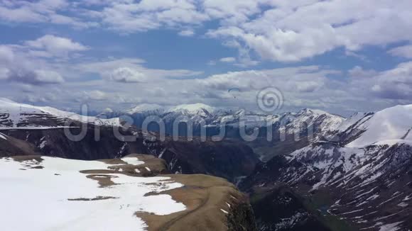滑翔伞在白雪皑皑的群山中飞翔视频的预览图