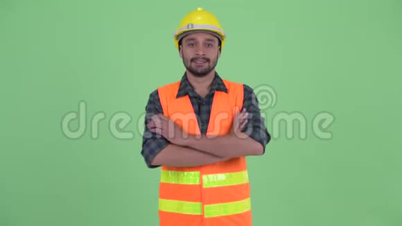 快乐的年轻留胡子的波斯建筑工人双臂交叉微笑视频的预览图