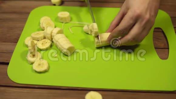 人们把香蕉切成块切割板上的薄片视频的预览图