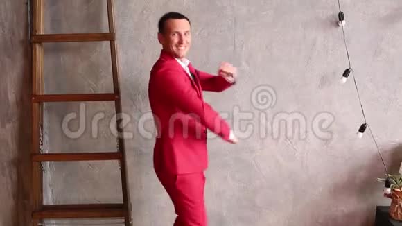 一个穿红色西装的快乐男人跳舞视频的预览图