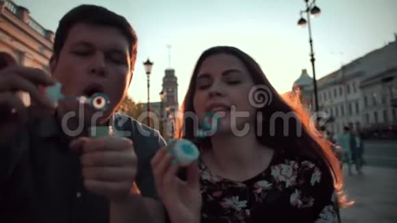 爱情和肥皂泡由男女年轻夫妇吹视频的预览图