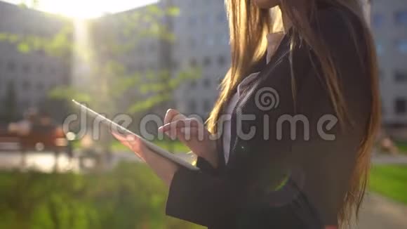 女商人使用数码平板电脑关闭步行在阳光明媚的早晨城市下面的动作专业人士视频的预览图