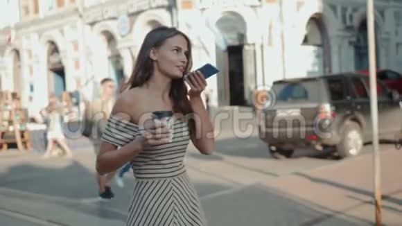 一个女孩用手机语音识别行走街道的肖像女语音学生留言助手ai视频的预览图