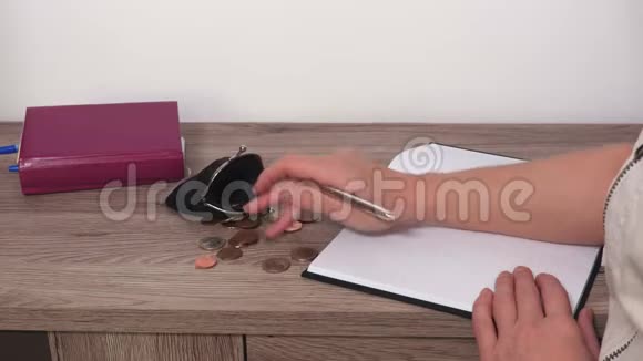女人会数硬币在垫子上做笔记视频的预览图