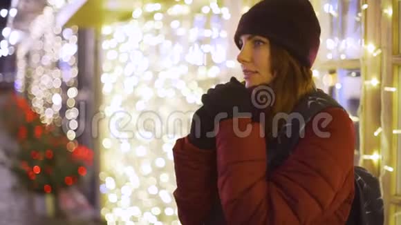 年轻的美女走在夜城在城市的街道上的圣诞装饰视频的预览图