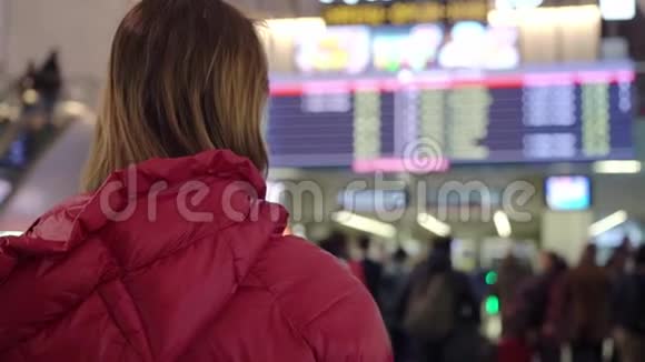 国际机场或火车站的美丽年轻旅游女孩靠近飞行信息板视频的预览图