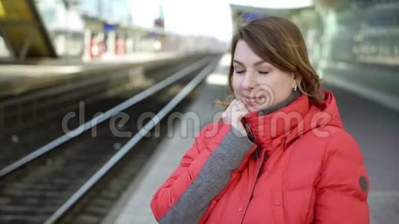 年轻女子站在车站站台等车视频的预览图