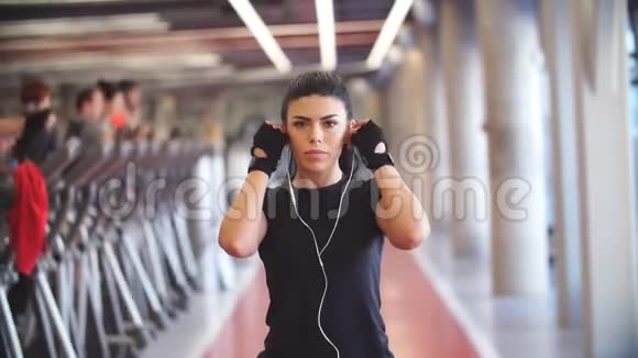 年轻的健身妇女在健身房用杠铃锻炼肌肉视频的预览图