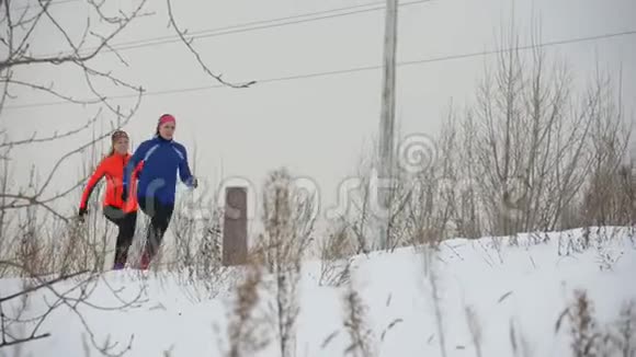 两个年轻女子在冬季室外严格地跑步视频的预览图