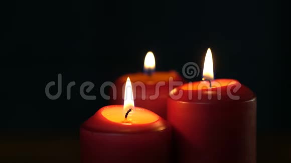 温暖的蜡烛在黑色的虚空中轻轻燃烧蜡烛在黑暗的背景下组合在一起视频的预览图