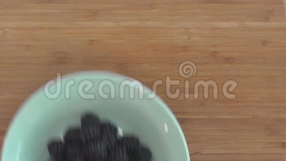 一个女人手把一碗装满黑莓的东西放在一个切割板上然后又把它们移走视频的预览图