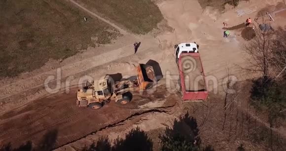 挖掘机用空中摄影无人机将沙子装入卡车视频的预览图