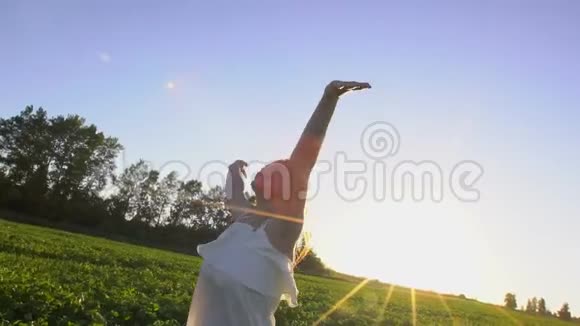 十几岁的夏天女孩在绿色的田野上奔跑在户外日落时举手快乐美丽微笑年轻快乐视频的预览图