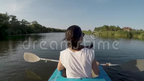 阳光明媚的一天女人在河上皮划艇视频的预览图