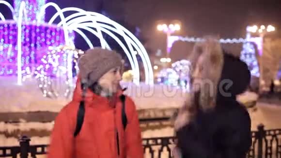 小女孩在冬天走在靠近圣诞树的城市中心广场上假日雪欢乐视频的预览图