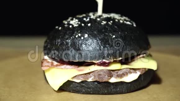 美味的黑汉堡有切肉熏肉奶酪和樱桃酱视频的预览图