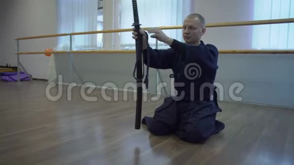 穿着和服的武士坐在地板上躺在保罗卡坦刀剑上视频的预览图