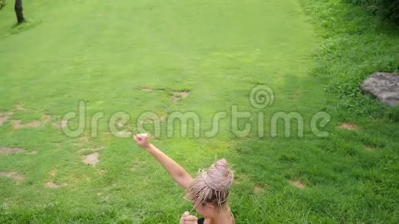 疯狂的懒惰女孩在公共公园的草地上玩得很开心恶作剧的概念视频的预览图