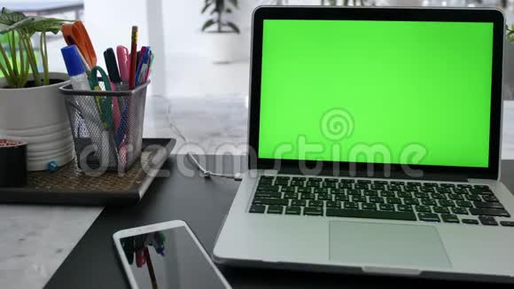 在客厅的办公桌上展示绿色彩色钥匙屏幕的笔记本电脑在背景舒适的客厅里多利鞋视频的预览图