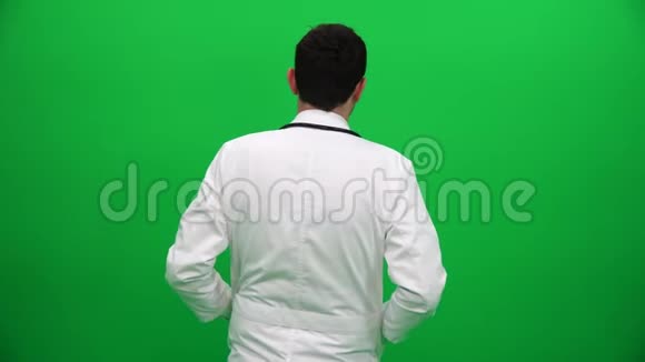 医生转过身来看着绿盒子背景上的摄像机视频的预览图