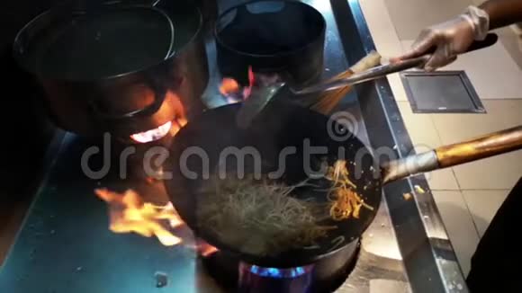 制作亚洲食物的烹饪在火上的平底锅上新鲜的面条和蔬菜视频的预览图