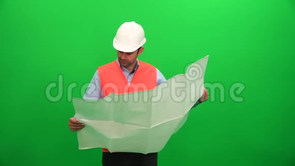建筑师检查绿色背景的技术施工图纸视频的预览图
