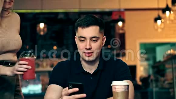 在咖啡店使用手机的年轻人视频的预览图