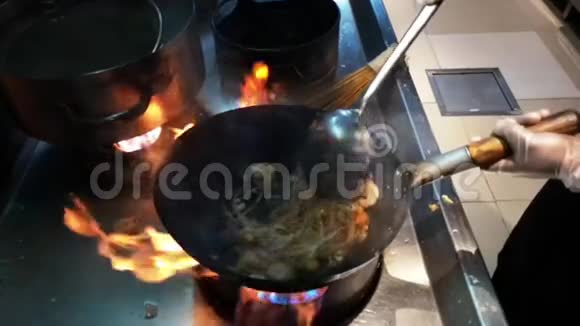 制作亚洲食物的烹饪在火上的平底锅上新鲜的面条和蔬菜视频的预览图
