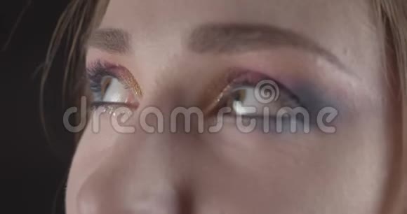 一张年轻可爱的白种人短发女性脸的特写肖像她的眼睛在前面摆着闪闪发光的妆容视频的预览图