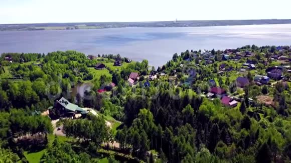 蓝色湖泊背景下的小镇剪辑湖边林区乡村的俯视图视频的预览图