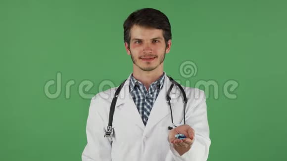 年轻的医生拿着绿苹果和一堆药丸视频的预览图