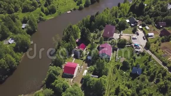 鸟瞰美丽的俄罗斯小村庄和郊区水边房屋剪辑令人叹为观止的森林地区视频的预览图