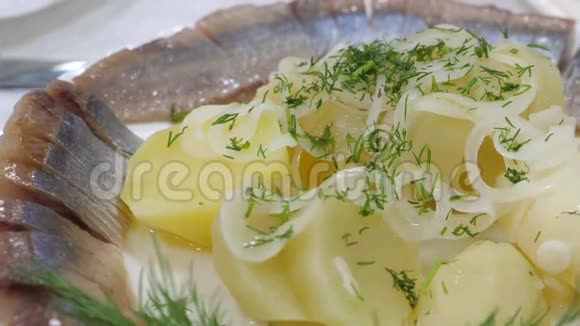 服务员桌上放着一盘咸鱼在餐厅里撒着青菜桌子上有美味的食物鲱鱼视频的预览图