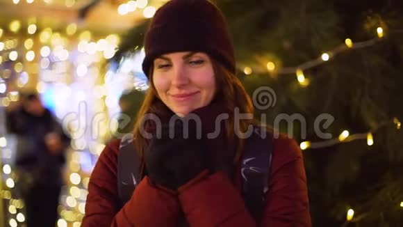 年轻的美女走在夜城在城市的街道上的圣诞装饰视频的预览图