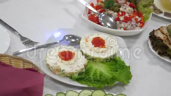 盘子里有红色鱼子酱和绿色沙拉的三明治节日餐桌桌子上有美味的食物视频的预览图