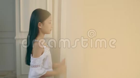 一个亚洲小女孩望着窗外视频的预览图