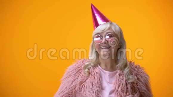 穿着粉色外套戴着圆眼镜的老妇人庆祝生日视频的预览图