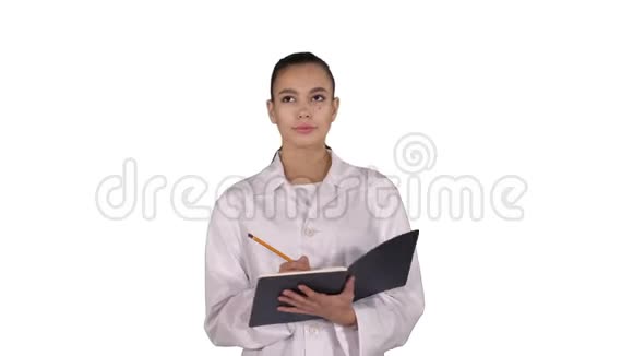 富有表现力的年轻女医生创意十足手持笔记本行走在白色背景下视频的预览图