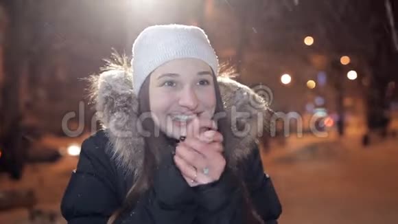 年轻女孩在冬天的夜晚在镜头上摆姿势冬天很冷视频的预览图