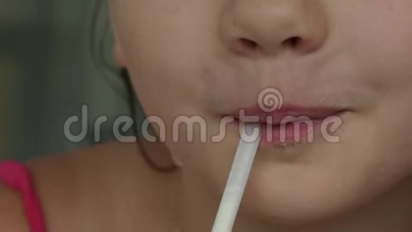 特写的孩子嘴唇通过吸管喝奶昔慢动作视频的预览图