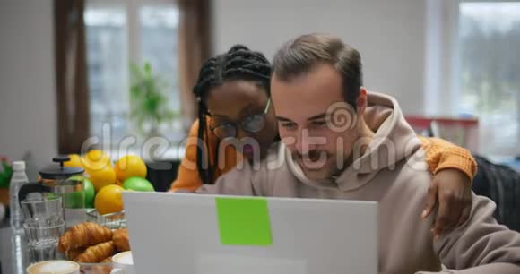 相爱的一对夫妇一起阅读社交网络中有关笔记本电脑的新闻视频的预览图