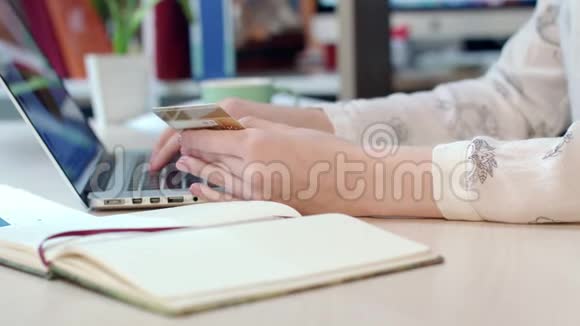 在线支付解决方案女人手拿信用卡用手提电脑视频的预览图