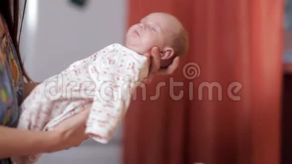 一位年轻的母亲让新生儿入睡小孩子和母亲幸福快乐视频的预览图