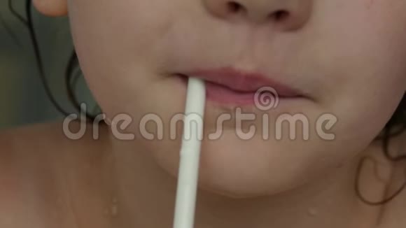 特写的孩子嘴唇通过吸管喝奶昔慢动作视频的预览图
