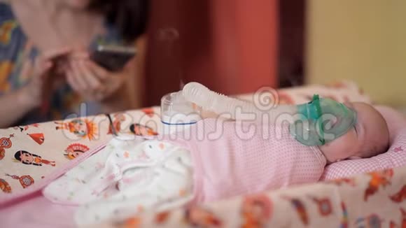 躺在床上婴儿被适当的装置吸入此时他的母亲使用视频的预览图