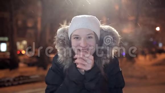 年轻女孩在冬天的夜晚在镜头上摆姿势冬天很冷视频的预览图