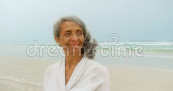 站在海滩上的一位思想活跃的非裔美国妇女的正面景色视频的预览图
